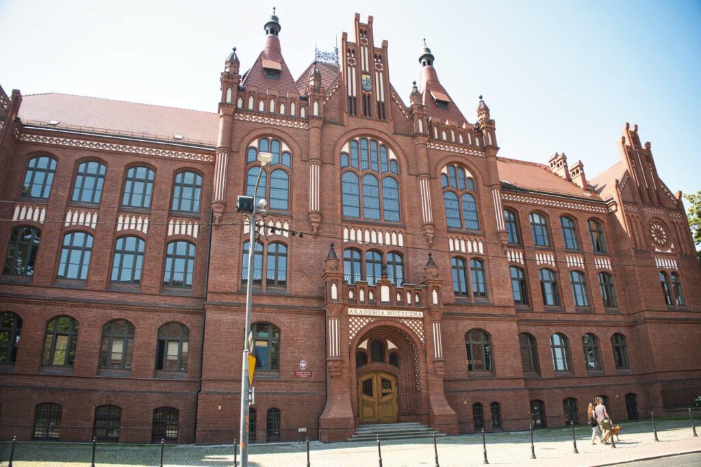 Die neugotische Backsteinfassade mit ihren spitzen Türmchen und dem großen Maßwerkfenster gehört zur Musikakademie ("Akademia Muzyczna") von Katowice.