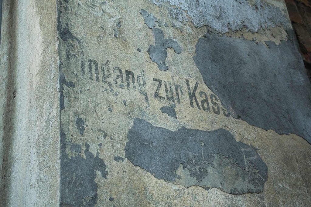 Ein stiller Zeuge der deutschen Vergangenheit: Verwitterte Schriftreste an der Fassade des Victoria-Theaters erinnern noch heute an die wechselvolle Geschichte der Stadt.