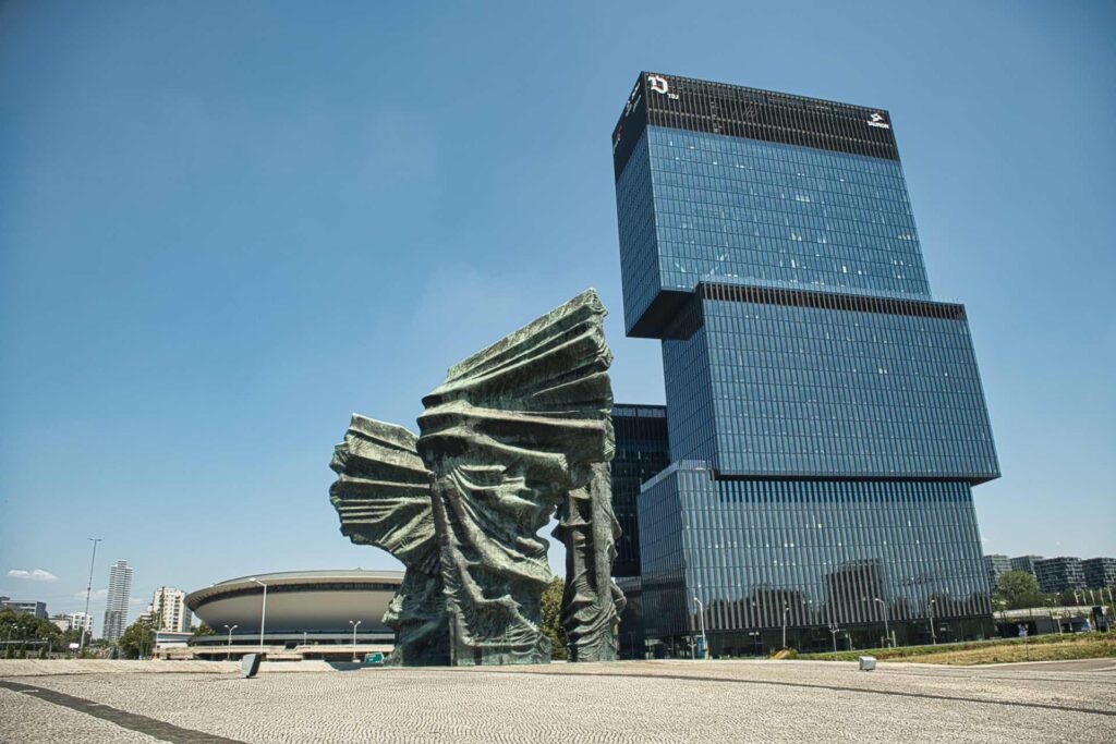 Das Denkmal der Schlesischen Aufstände vor der Kulisse des modernen Bürohochhauses KTW II in Katowice.