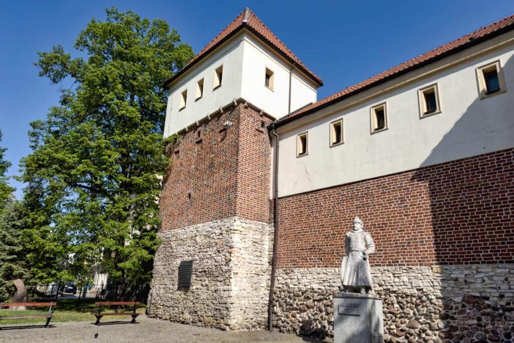 Überreste der mittelalterlichen Stadtmauer mit Wehrturm erinnern an die einstige Befestigung von Gliwice – daneben ein Denkmal für König Stefan Batory. Heute wird dies Piastenburg genannt, doch belegt ist offiziell nur eine Nutzung als Gefängnis.