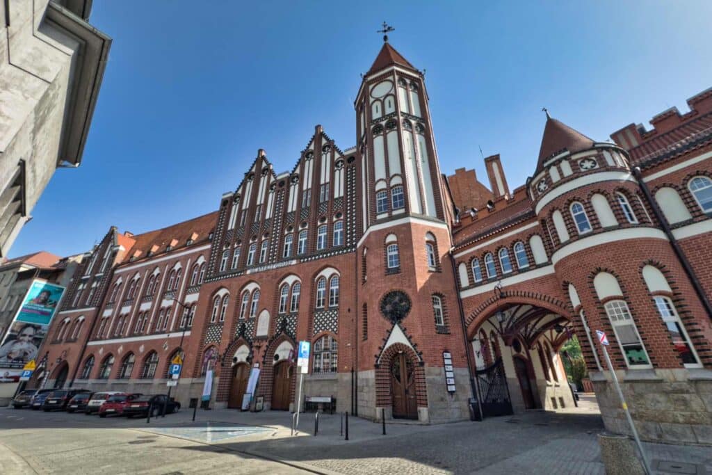 Die Hauptpost von Gliwice beeindruckt mit ihrer prachtvollen Backsteingotik-Fassade, den markanten Türmchen und reichen Verzierungen – ein echtes Wahrzeichen aus der Wende vom 19. zum 20. Jahrhundert und eines der schönsten Beispiele historistischer Architektur der Stadt.